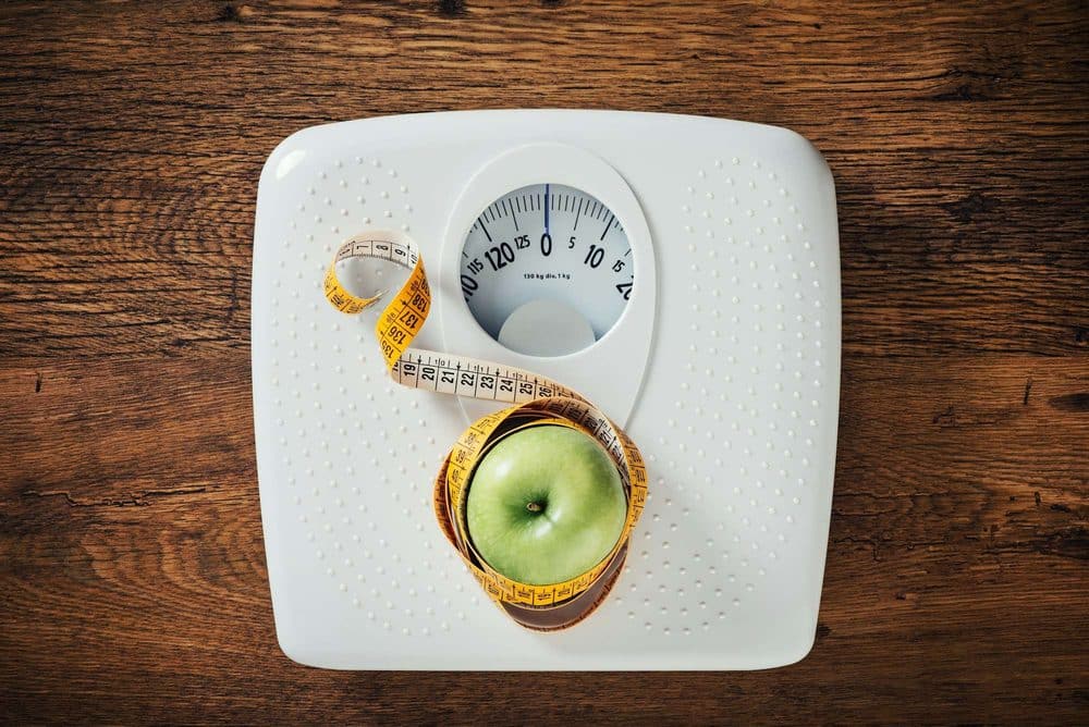 Weight loss — scale with measuring tape and green apple